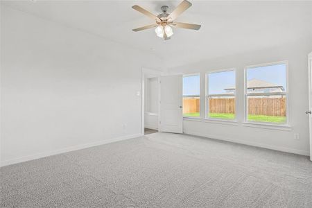 Carpeted empty room featuring lofted ceiling and ceiling fan