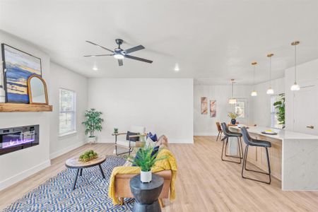 Living room with ceiling fan and light hardwood / wood-style floors