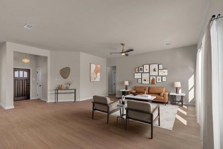 Living room with ceiling fan with notable chandelier and light wood-type flooring