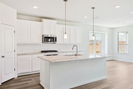 Kitchen featuring sink, stainless steel appliances, backsplash, and light hardwood / wood-style flooring