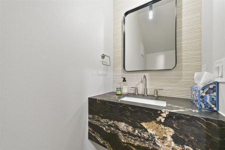 Bathroom with tasteful backsplash and vanity