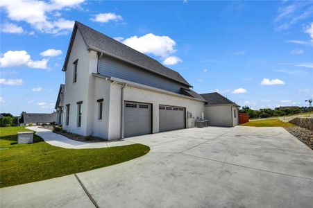 View of home's exterior featuring a garage, central AC unit, and a yard