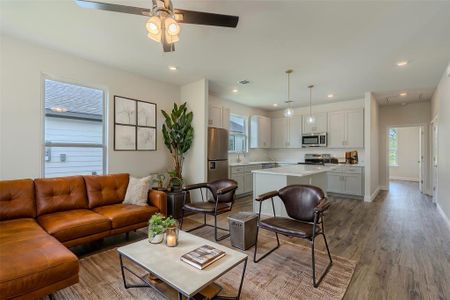 Living room with hardwood / wood-style floors, sink, and ceiling fan