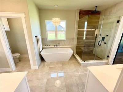 Full bathroom featuring an inviting chandelier, tile patterned flooring, vanity, plus walk in shower, and toilet