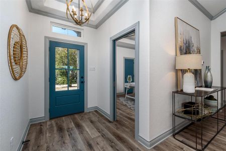 Bright entryway with designer paint color door and trim work.