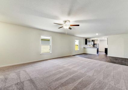 Medina great room with carpet in the living room, hardwood floors in the dining room and kitchen, and brown overhead ceiling fan