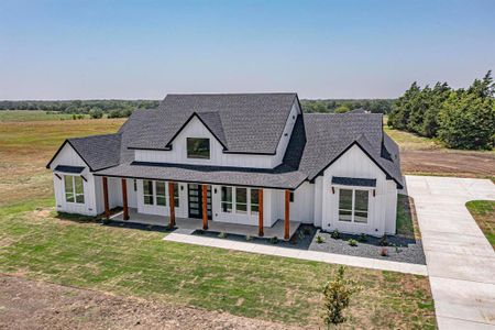 Modern farmhouse style home with covered porch and a front lawn