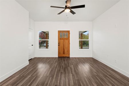 Empty room with ceiling fan and dark wood-type flooring