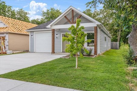 View of front of property featuring a garage and a front lawn