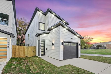 View of front facade featuring a yard and a garage