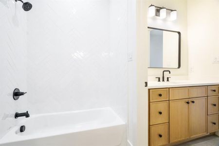 Bathroom featuring tile patterned flooring, vanity, and tub / shower combination