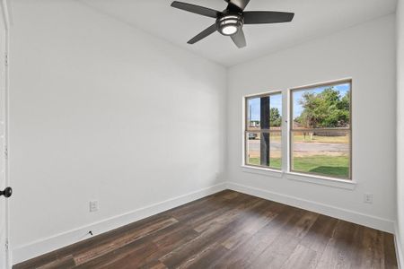 Unfurnished room with ceiling fan and dark hardwood / wood-style floors