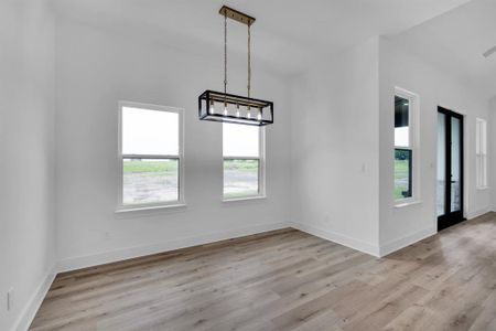 Unfurnished dining area with a notable chandelier and light wood-type flooring