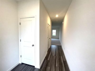 Hallway with dark wood-style floors and baseboards