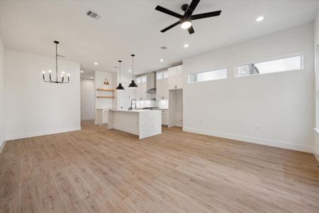 The living room features a ceiling fan, recessed lighting, and large windows. 10 ft ceilings are featured throughout the entire home!