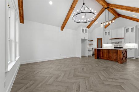 Kitchen with white cabinets, beamed ceiling, pendant lighting, and a kitchen island