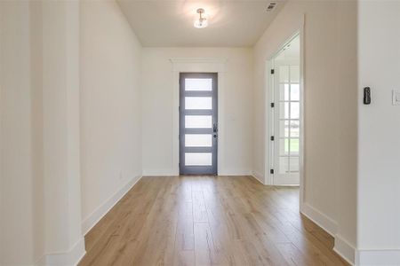 Entrance foyer with a wealth of natural light and light hardwood / wood-style flooring