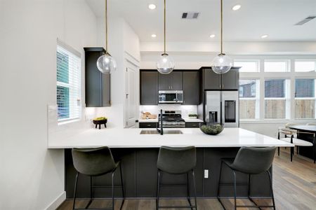 Modern Chef's Kitchen: Sleek cabinetry and stainless steel appliances are complemented by elegant pendant lighting and a spacious island, perfect for both casual dining and culinary creativity.