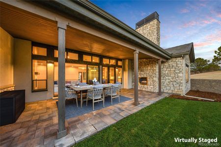 Covered patio, accessed by the opening glass wall, and complete with outdoor fireplace with statement stone wall surround. *This photo has been virtually staged.