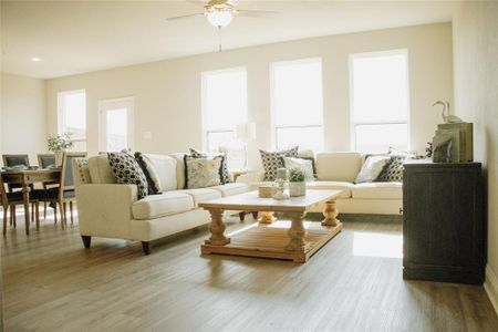 Living room with light hardwood / wood-style floors and ceiling fan