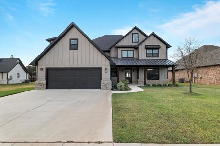 Modern farmhouse style home with a front yard, central AC, and a garage