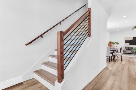 Stairway with ceiling fan and light wood-type flooring