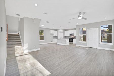 Unfurnished living room featuring ceiling fan, light wood-type flooring, and sink