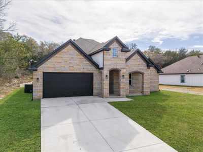 View of front of house featuring a garage and a front yard