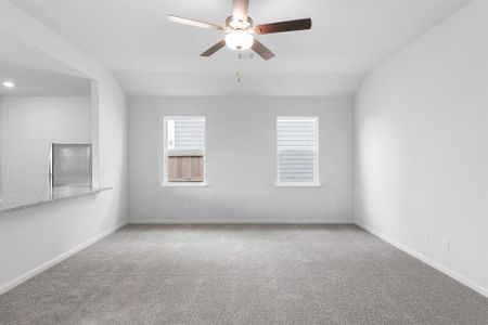 Carpeted living room featuring ceiling fan and light carpet