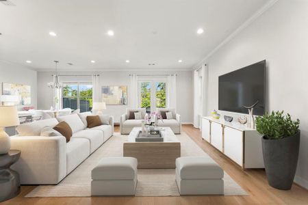 Large windows and French doors grace the back of the home, leading to the plush outdoor green space.