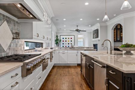 Kitchen with white cabinetry, backsplash, pendant lighting, and appliances with stainless steel finishes