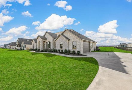 French provincial home featuring a garage and a front lawn