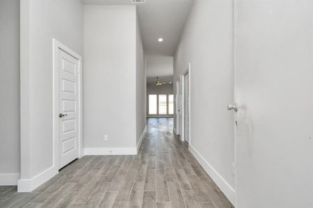 Greeted by a elegant glass front door (to be installed), the entrance beckons with high ceilings, adorned with elegant wood-look tile flooring and oversized baseboards. Sample photo of completed home with similar plan. As built color and selections will vary.