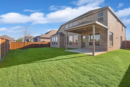 Back of house featuring a lawn and a patio