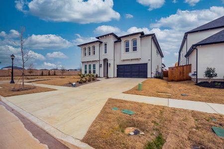 View of front of house with stucco siding, an attached garage, driveway, and fence