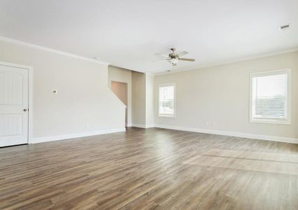 Open living room with a ceiling fan and vinyl flooring.