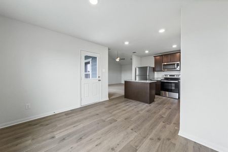 Kitchen featuring a center island, light hardwood / wood-style flooring, ceiling fan, dark brown cabinets, and stainless steel appliances