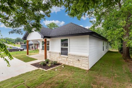 Side view of home with lawn and beautiful trees