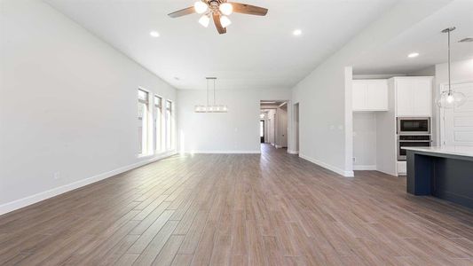 Unfurnished living room with light hardwood / wood-style floors and ceiling fan