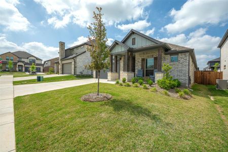 Craftsman-style home with a garage, central AC, covered porch, and a front yard