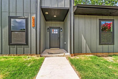 Doorway to property featuring a lawn