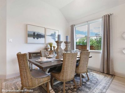 Dining room with light hardwood / wood-style floors and lofted ceiling