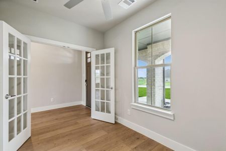 Spare room featuring ceiling fan, light hardwood / wood-style flooring, and french doors