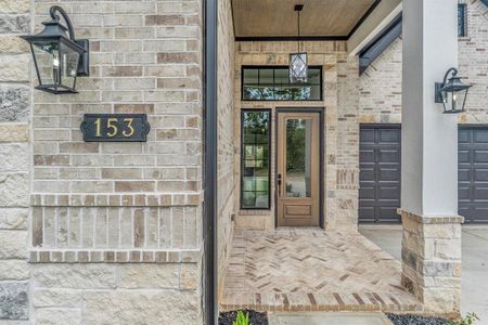 Warm and inviting chevron bricked entry with natural wood toned door