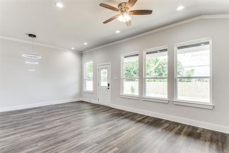 Empty room with dark hardwood / wood-style flooring, ceiling fan, and crown molding