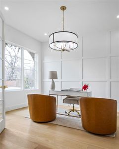 Office area with light wood-type flooring and a chandelier