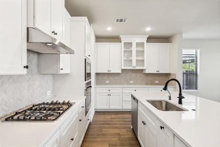 Kitchen featuring backsplash, appliances with stainless steel finishes, white cabinetry, dark hardwood / wood-style floors, and sink