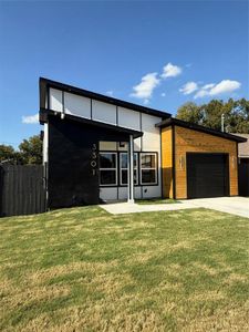 Contemporary house featuring a garage and a front lawn