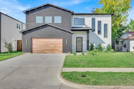 Modern home featuring a garage and a front lawn