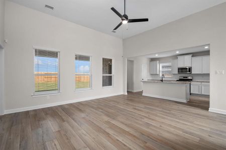 The spacious living room features high  ceilings and tons of natural light.